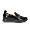 Black patent leather loafer with a platform sole on a white background