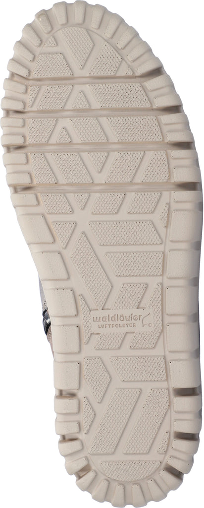 Close-up of a beige boot sole with brand logo on a white background