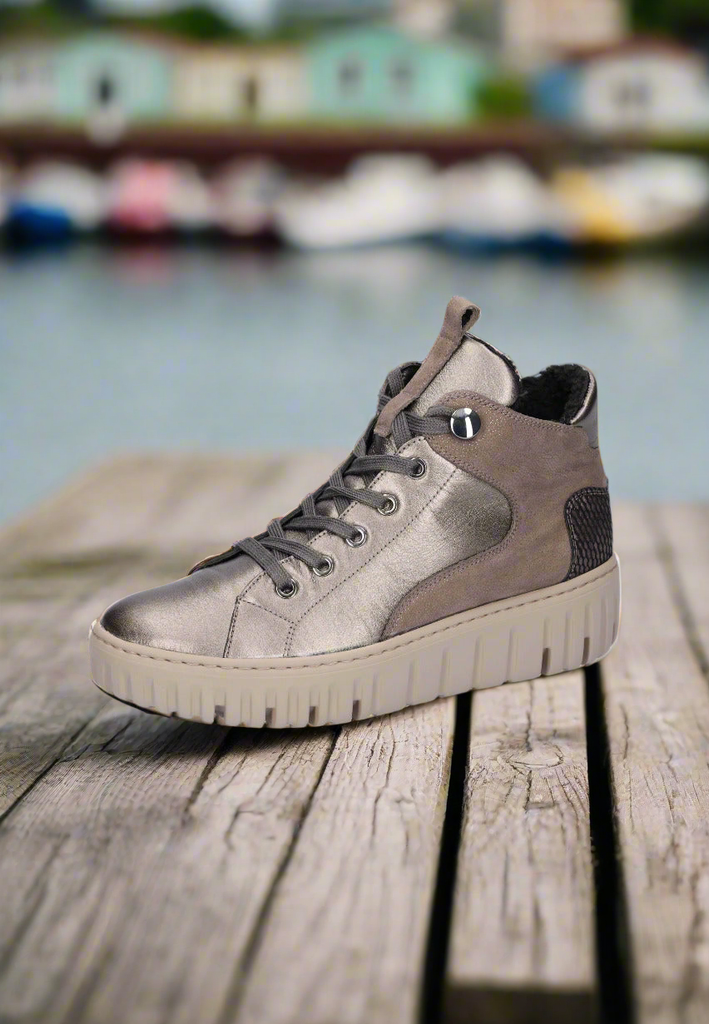 Gray high-top sneakers on a wooden surface with a blurred waterfront background