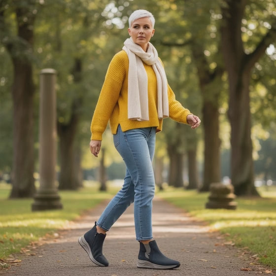 A stylish pair of Ladies Rieker Zip Sneaker Boots Wedge in navy blue. The boots feature a comfortable wedge heel, zip closure on the side, and a smooth leather finish. They are perfect for casual or city wear, combining fashion and comfort effortlessly